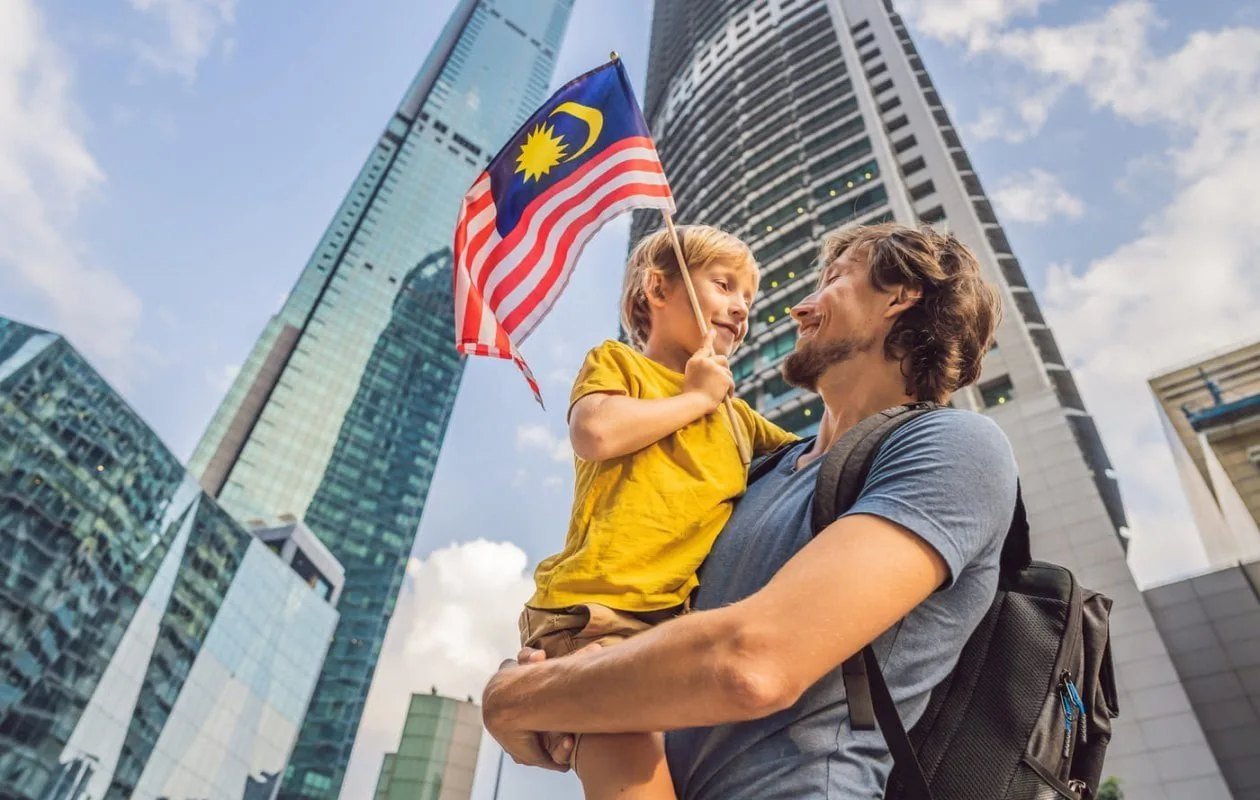 Family in Kuala Lumpur with Malaysian flag — PVIP Premium Visa Programme
